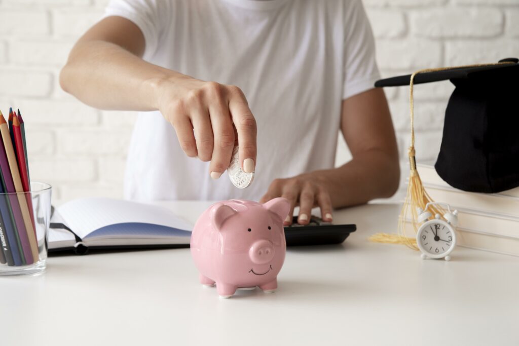 Représentation des économies générées par l'entreprise en montrant un homme mettant une pièce dans une tirelire cochon rose.